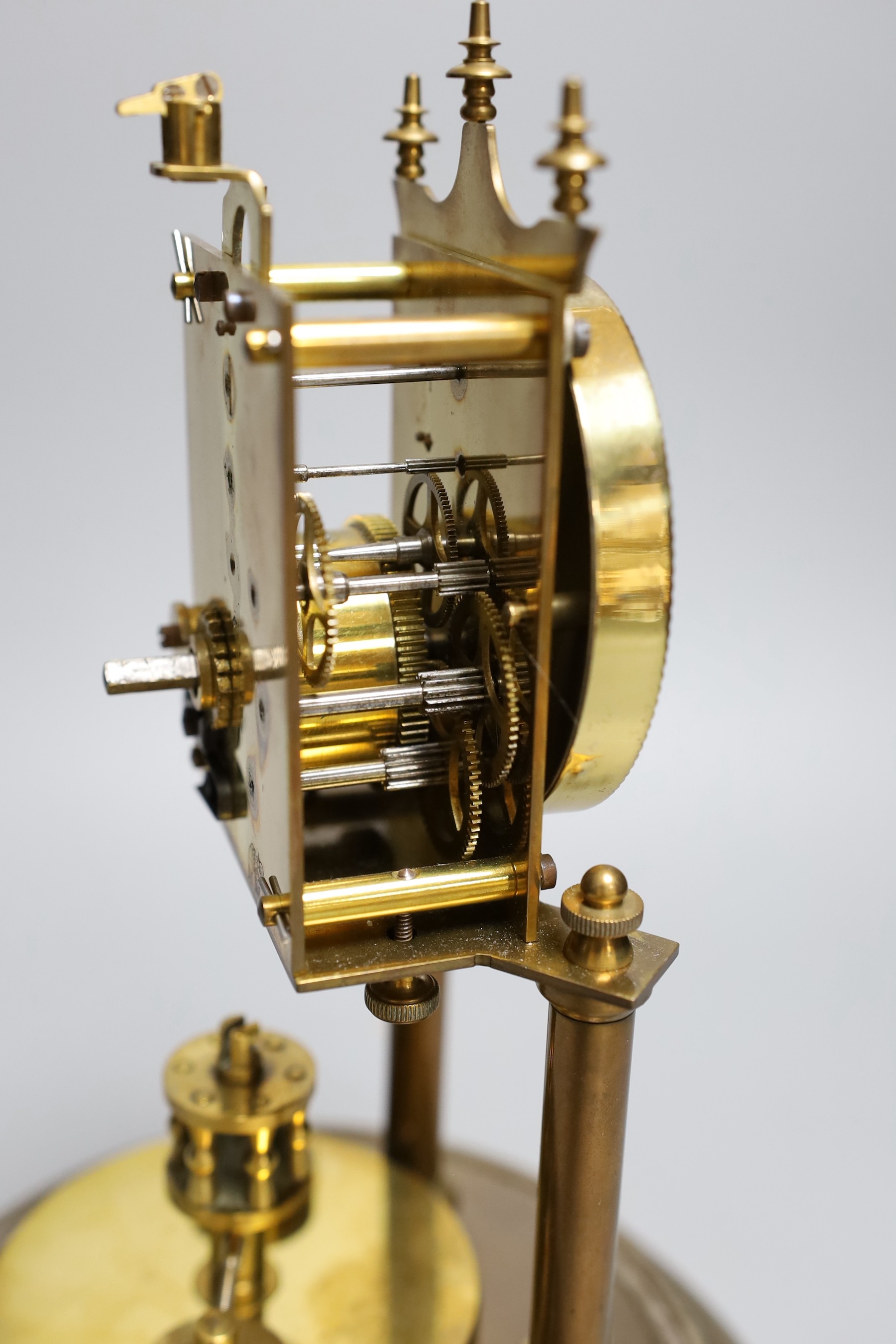 A German 400 day brass mantel timepiece, under a glass dome, 30cm total